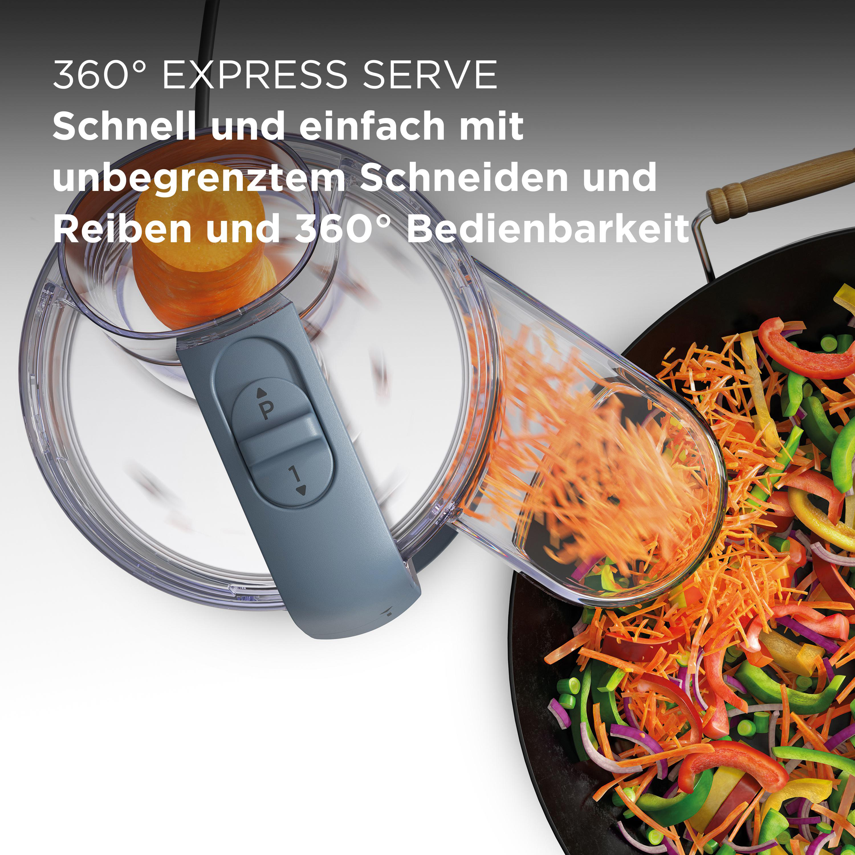 Küchenmaschine schneidet Karotten in einen Wok mit Gemüse.