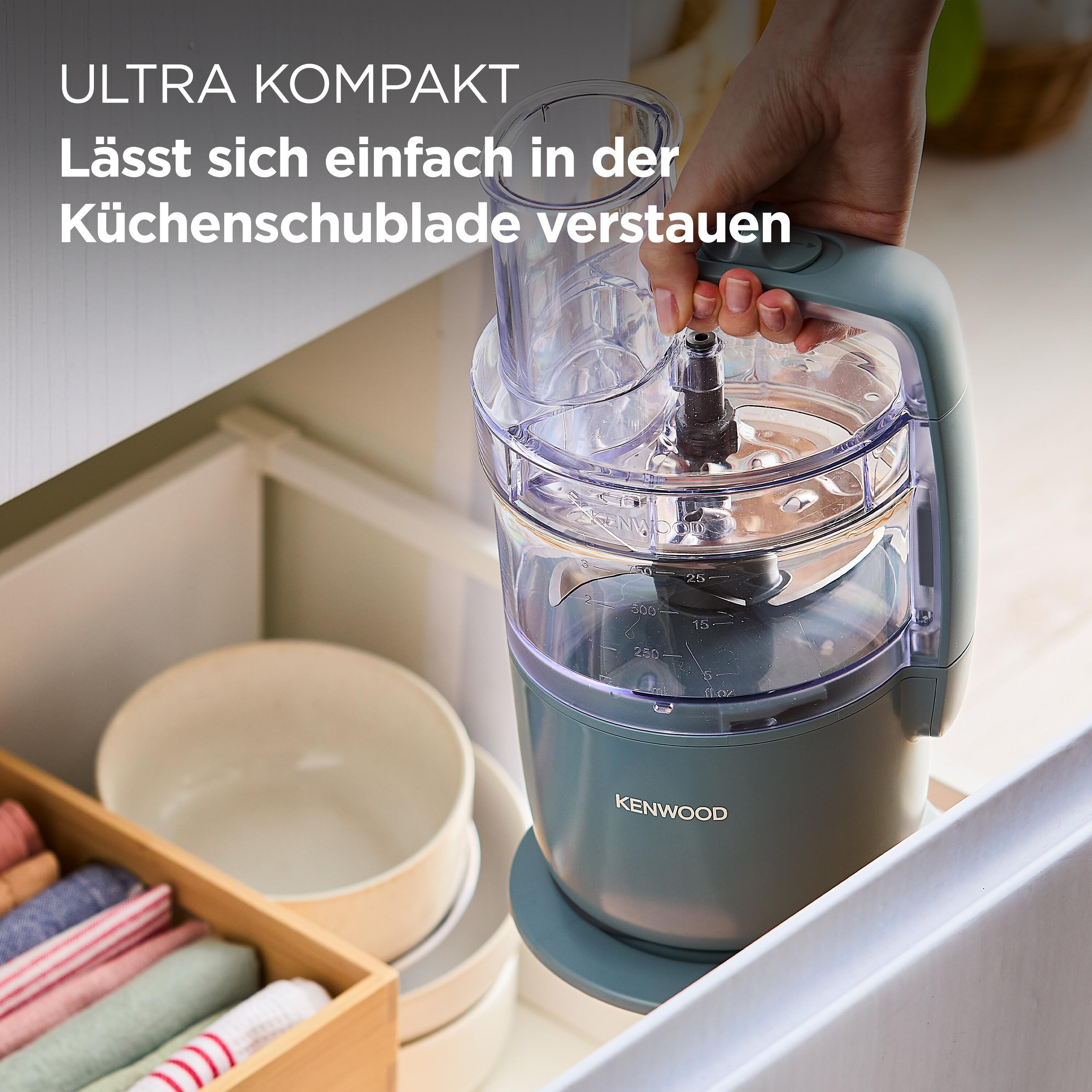 Frau, die einen Küchenmixer hält und ihn in einer Schublade zeigt.