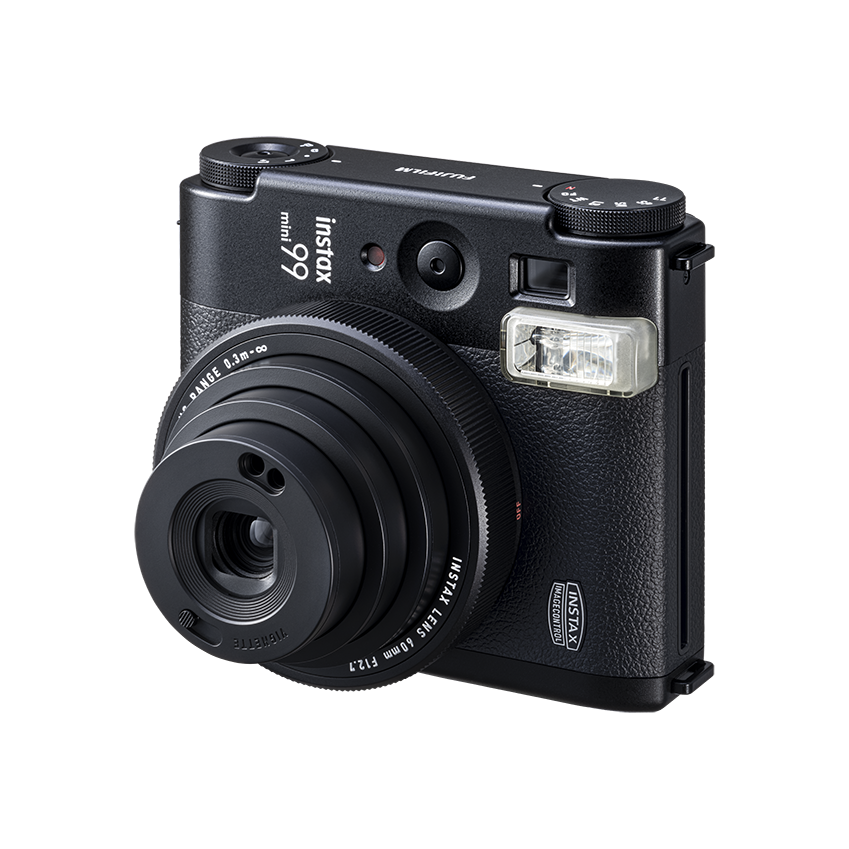 Siyah Instax Mini 99 kamera. Açılı görünüm. Objektif ve flaş görünür. Siyah arka plan.