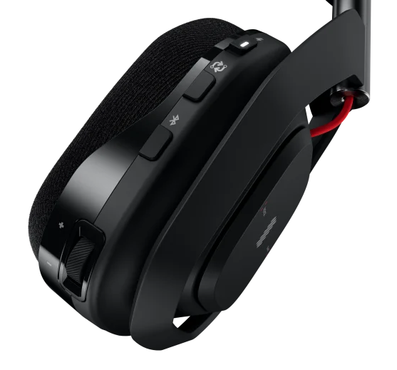 Zbliżenie panelu sterowania czarnego zestawu słuchawkowego do gier. Przyciski i pokrętło. Ciemne tło.