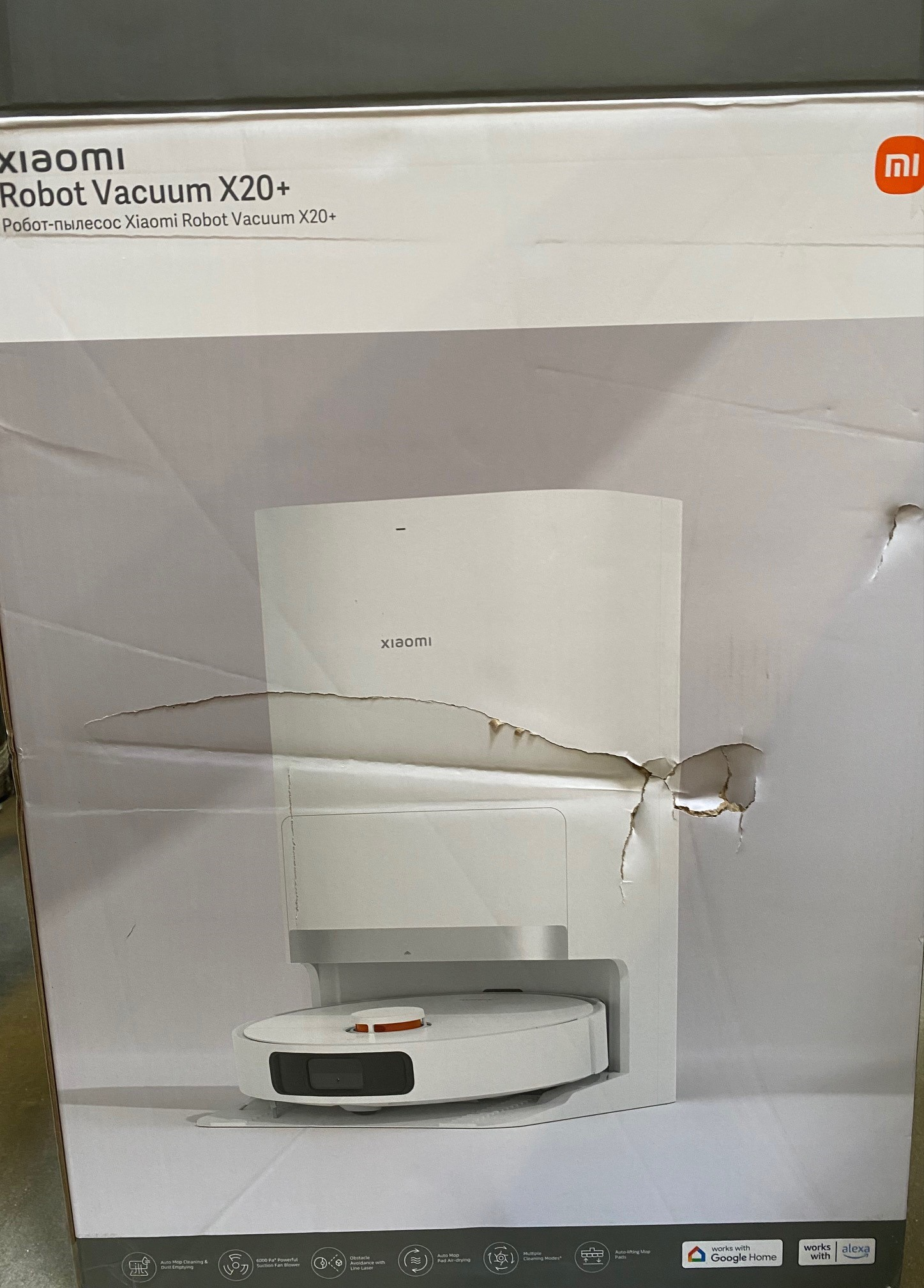 Białe pudełko Xiaomi Robot Vacuum X20+ z przecięciem i robotem w środku.