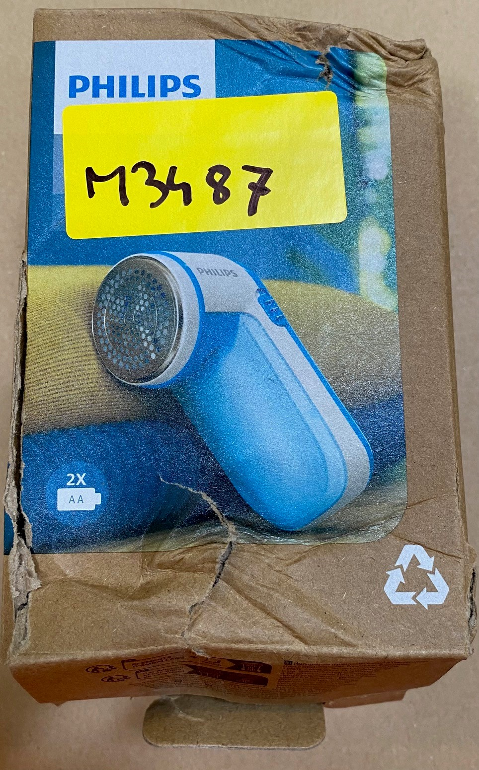 Pudełko golarki do tkanin Philips, ze zdjęciem golarki i żółtą naklejką.