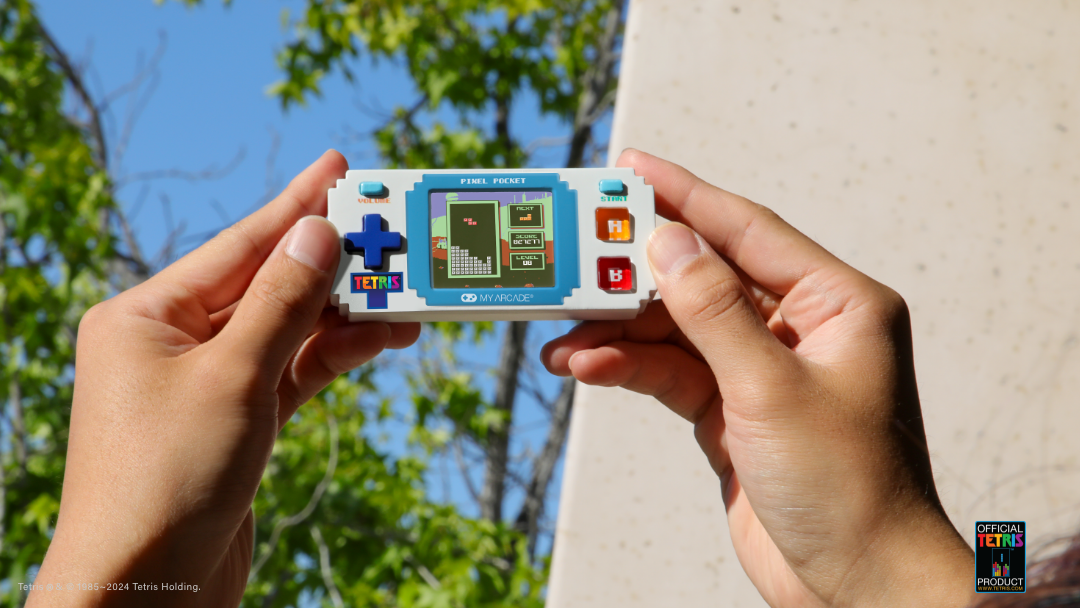 Bir kişinin elinde Tetris Pixel Pocket el oyun konsolu.