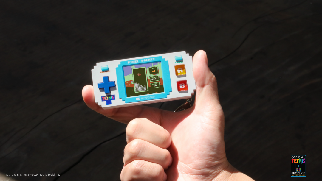 Bir el, Tetris Pixel Pocket el oyun konsolu tutuyor.