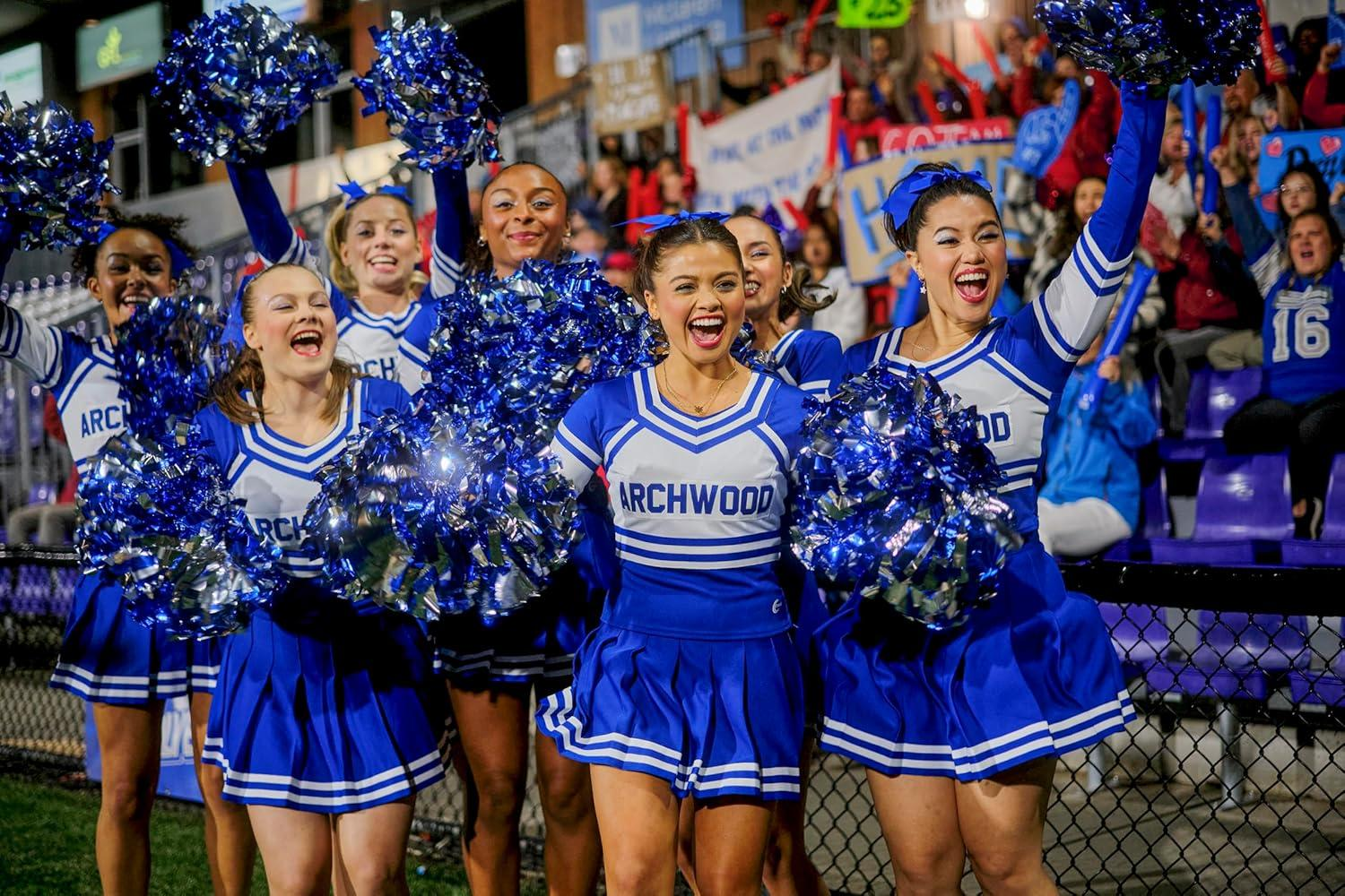 Cheerleader in blauen und weißen Uniformen, jubeln bei einem Footballspiel.