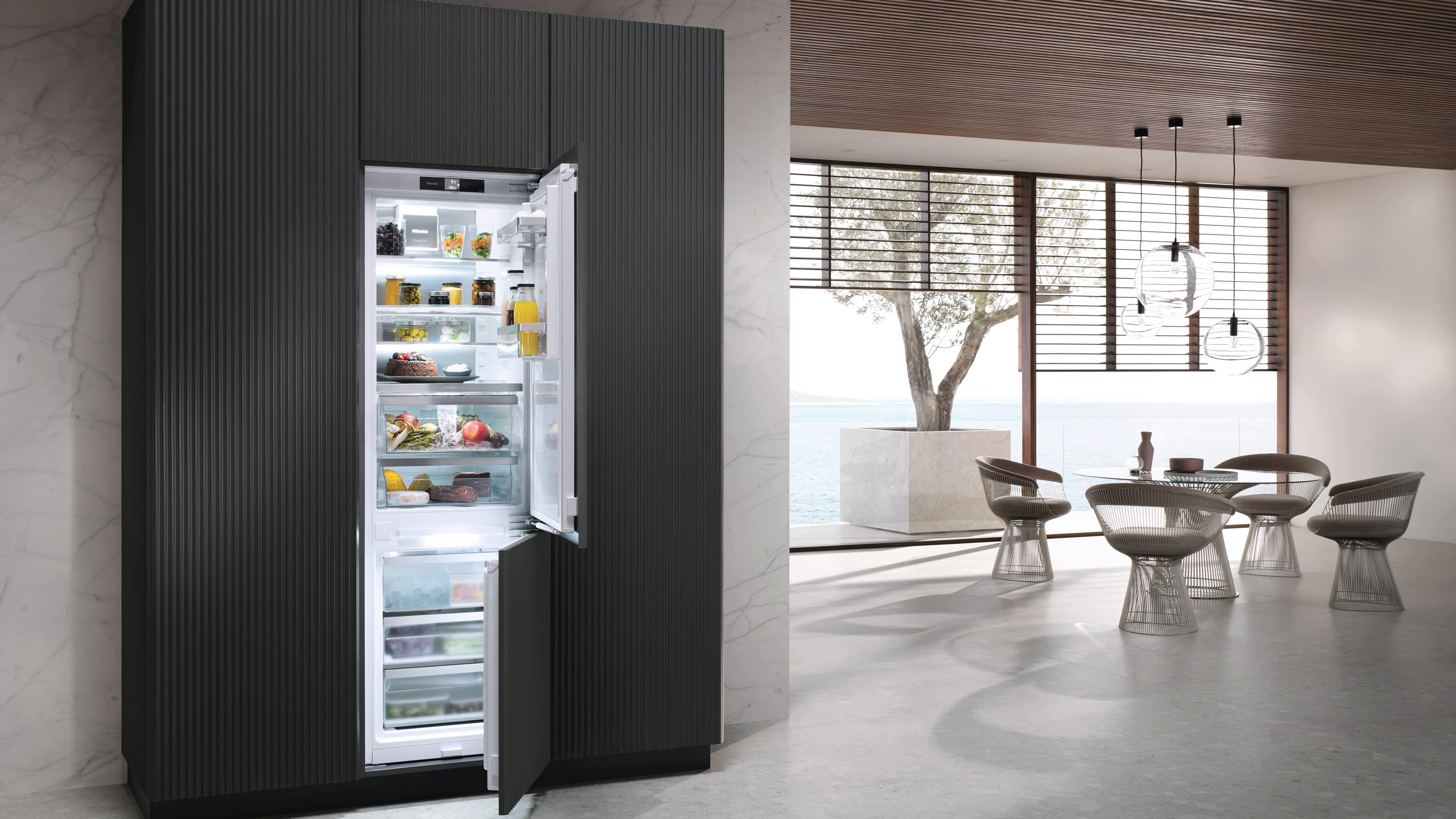 Eine moderne Küche mit Kühlschrank. Der Kühlschrank ist geöffnet und zeigt Lebensmittel darin.