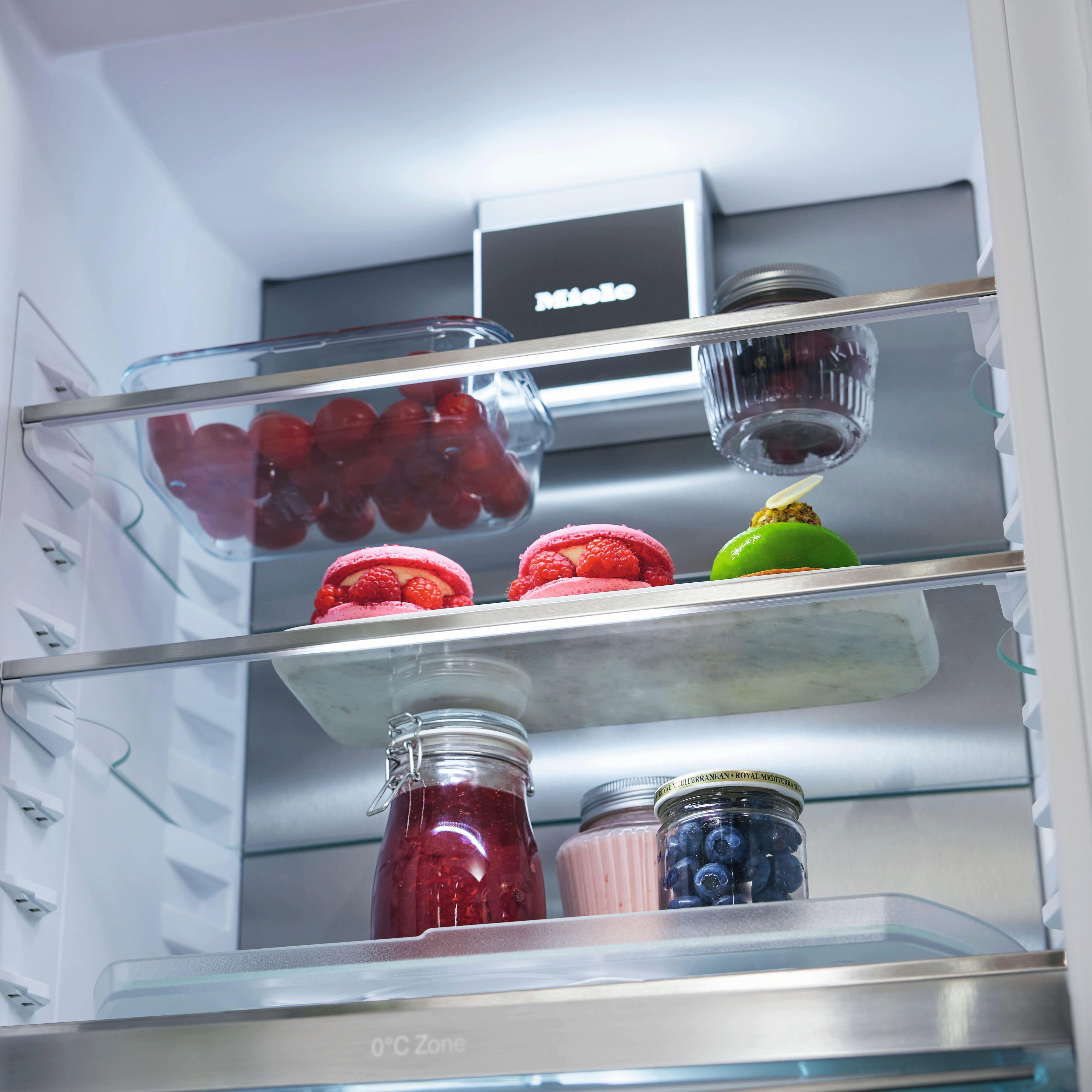 Im Kühlschrank enthalten Regale Desserts und andere Lebensmittel in Glasbehältern.