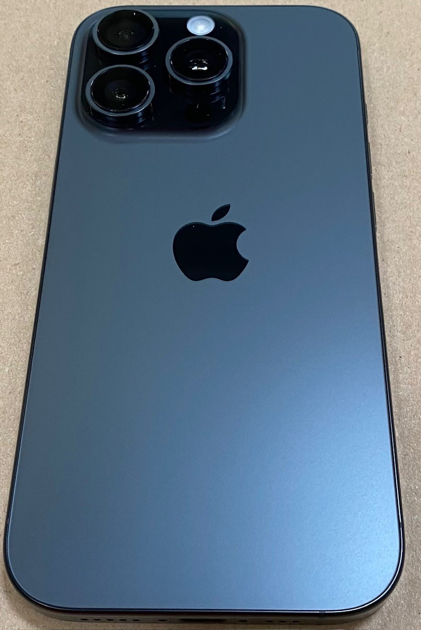 Tył ciemnoszarego iPhone'a z trzema aparatami, lampą błyskową i logo Apple.