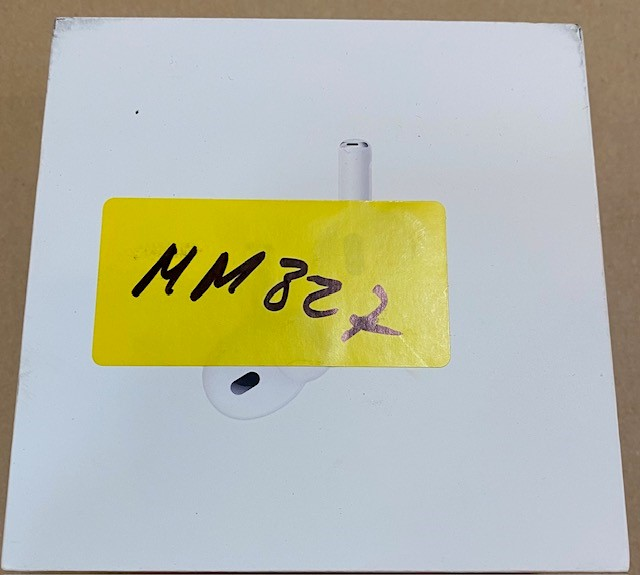 Białe pudełko z żółtą naklejką i etui na słuchawki. Pudełko ma odręczną notatkę.