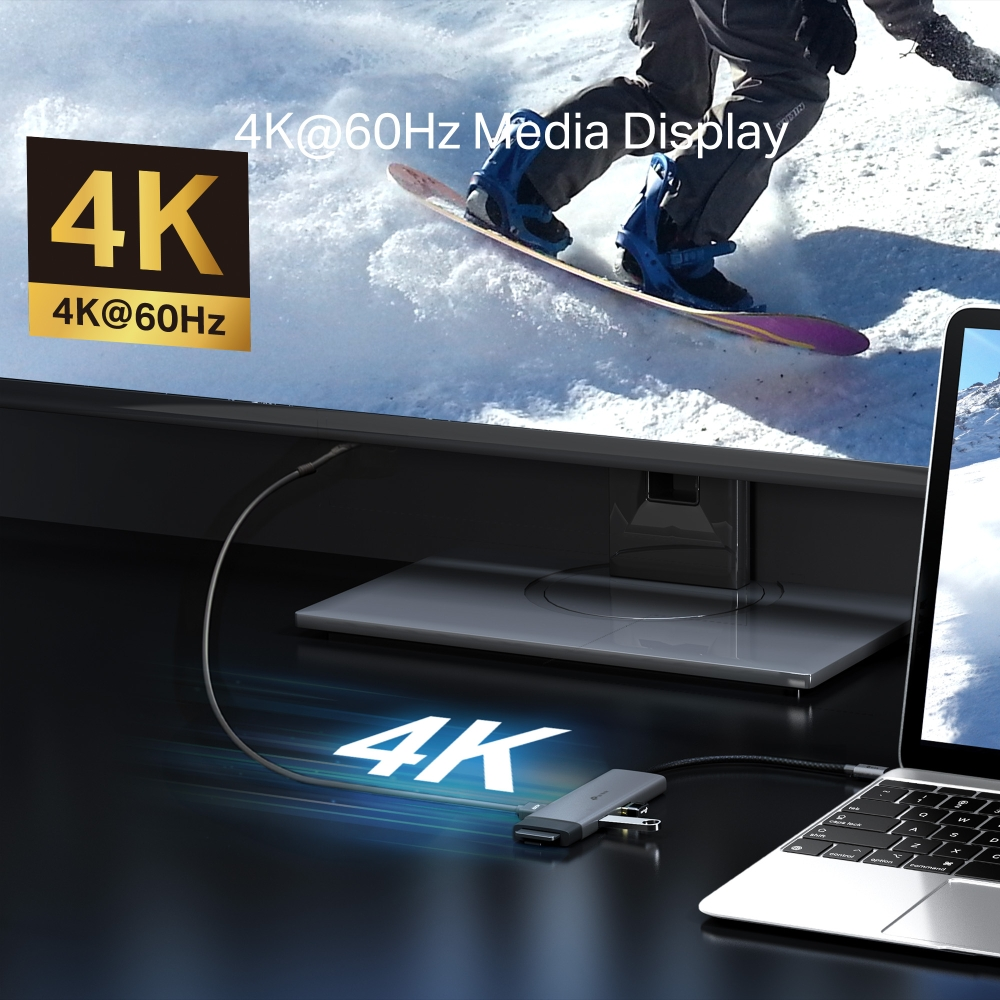 4K monitör, snowboardcuyu gösterir. Bir kabloyla bir dizüstü bilgisayara bağlı. Bir 4K hub bağlı. Metin: 4K@60Hz Media Display.