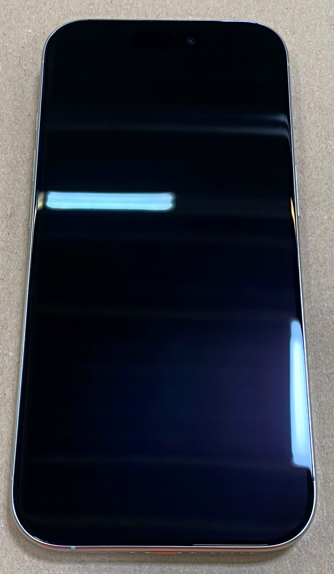 iPhone z czarnym ekranem, pokazujący widok z przodu telefonu.