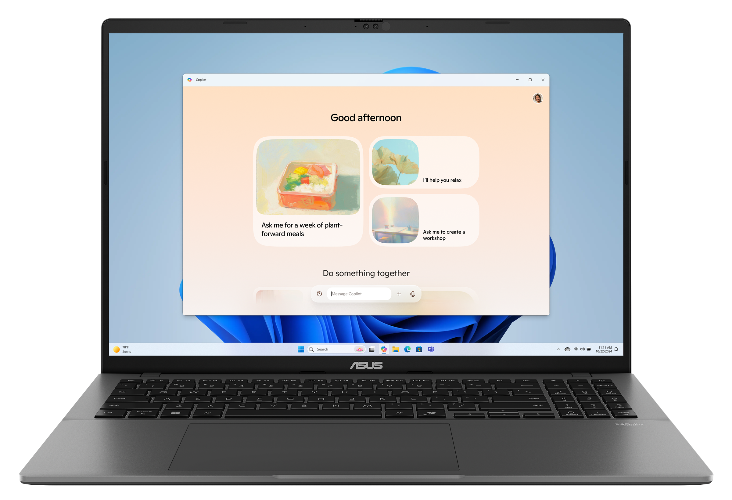 Szary laptop otwarty, pokazujący stronę internetową z jasnym tłem i obrazami. Logo ASUS widoczne.