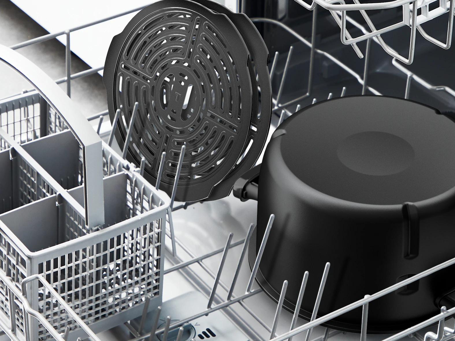 Czarne części frytkownicy w zmywarce. Zawiera kosz, okrągły grill i garnek. Zmywarka jest szara i biała.