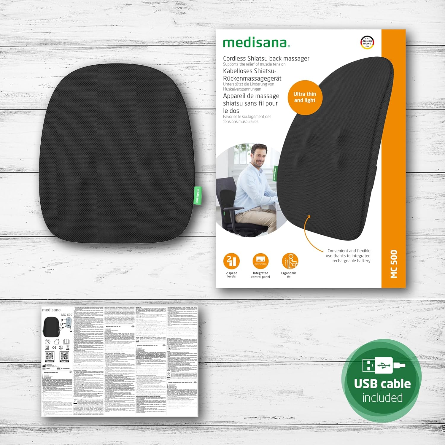 Embalaje con un masajeador de espalda shiatsu negro. Texto en alemán, diagramas y un cable USB.