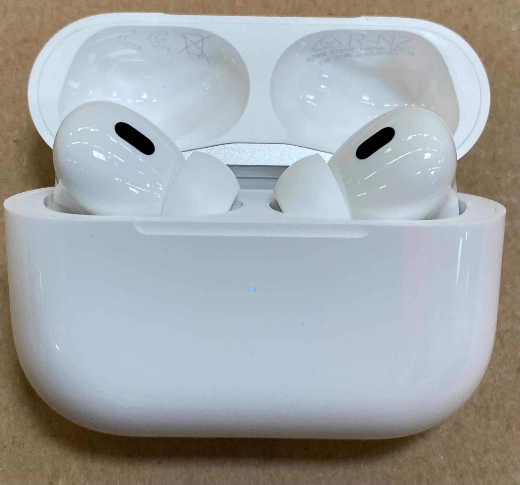 Białe AirPods Pro w białym etui ładującym, otwarte, pokazujące dwie słuchawki.