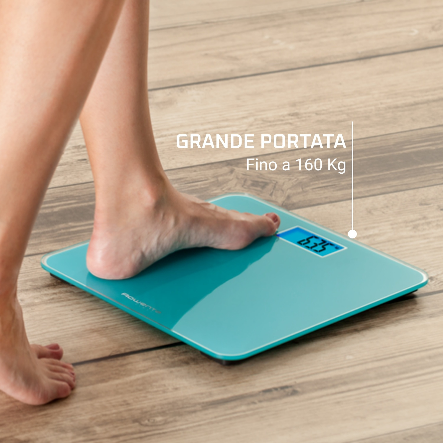 Piede di una persona su una bilancia turchese che mostra 63,5 kg. Pavimento in legno sullo sfondo.