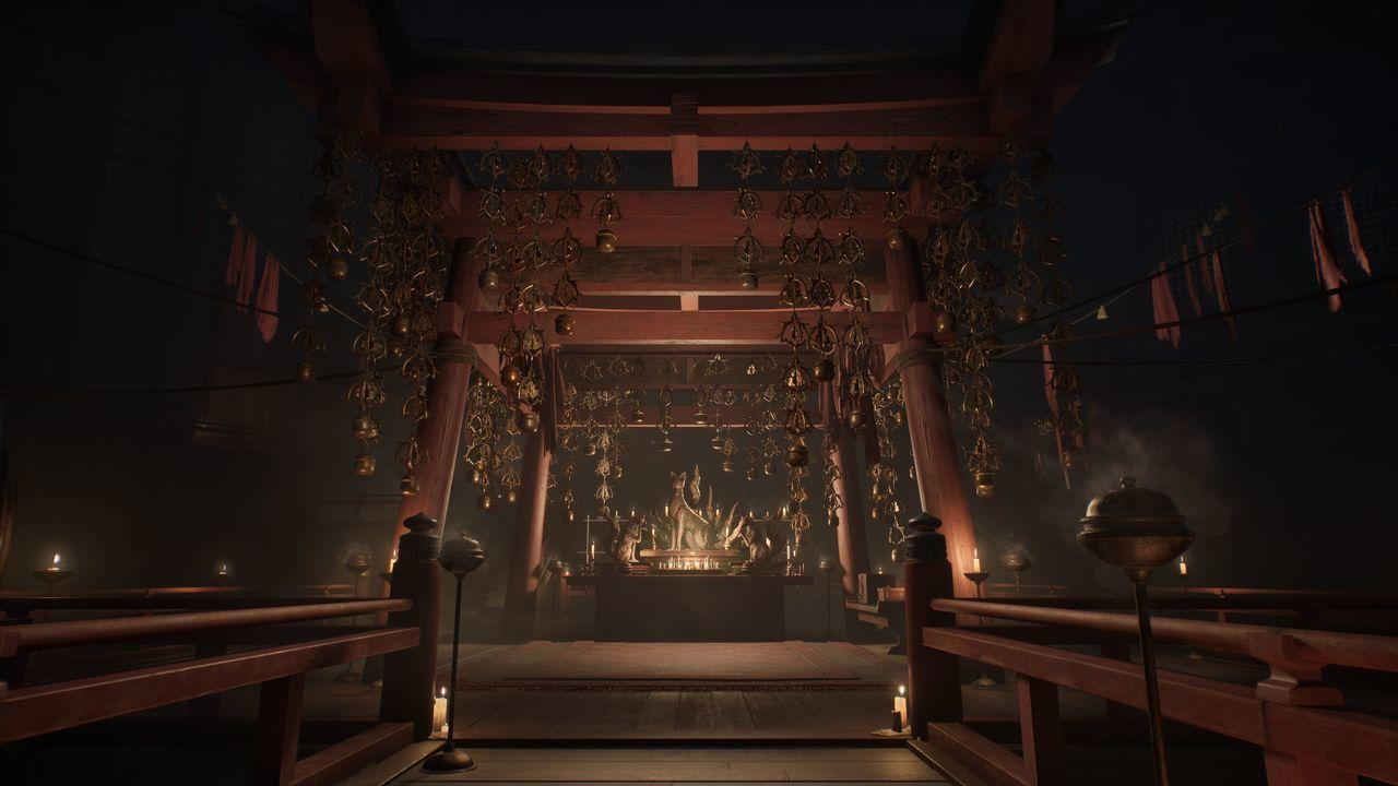 In einem Tempel mit roten Strukturen, goldenen Glocken und Kerzen. Eine Statue steht in der Mitte. Schwach beleuchtet.