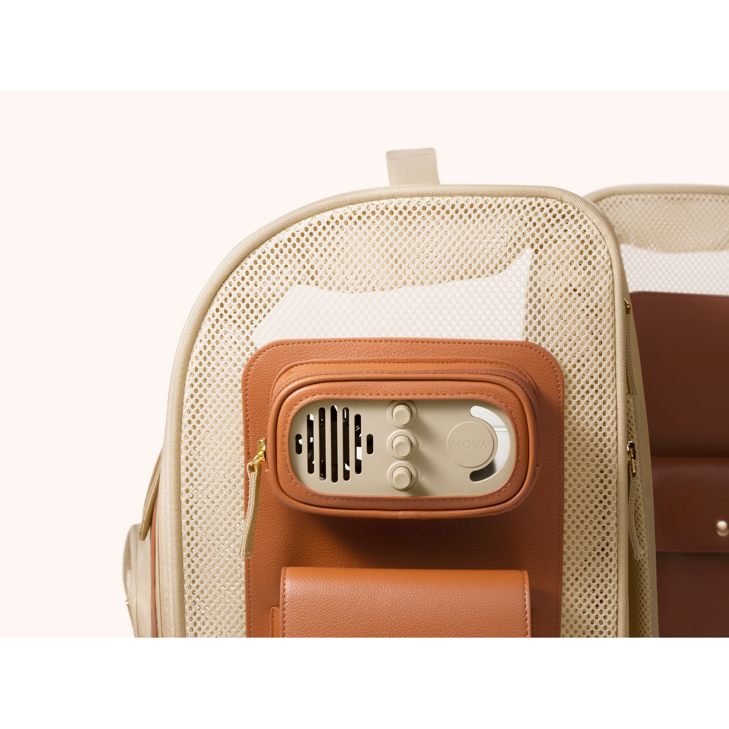 Tan pet carrier with mesh, brown leather accents, speaker panel, and zipper.