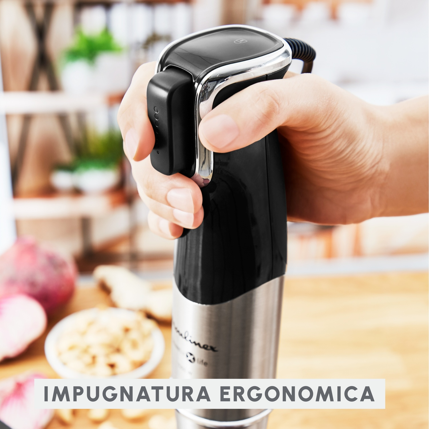 Una mano tiene un frullatore Moulinex nero e argento. Testo in basso: 'IMPUNATURA ERGONOMICA'.