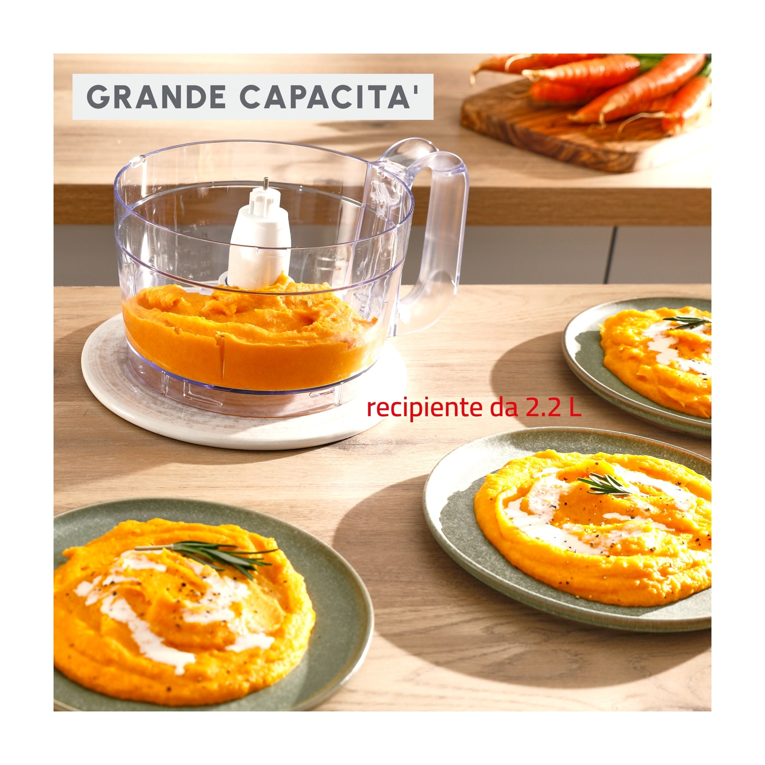 Frullatore con purea di arance. Tre piatti di purea. Carote e tagliere sullo sfondo. Grande Capacité.