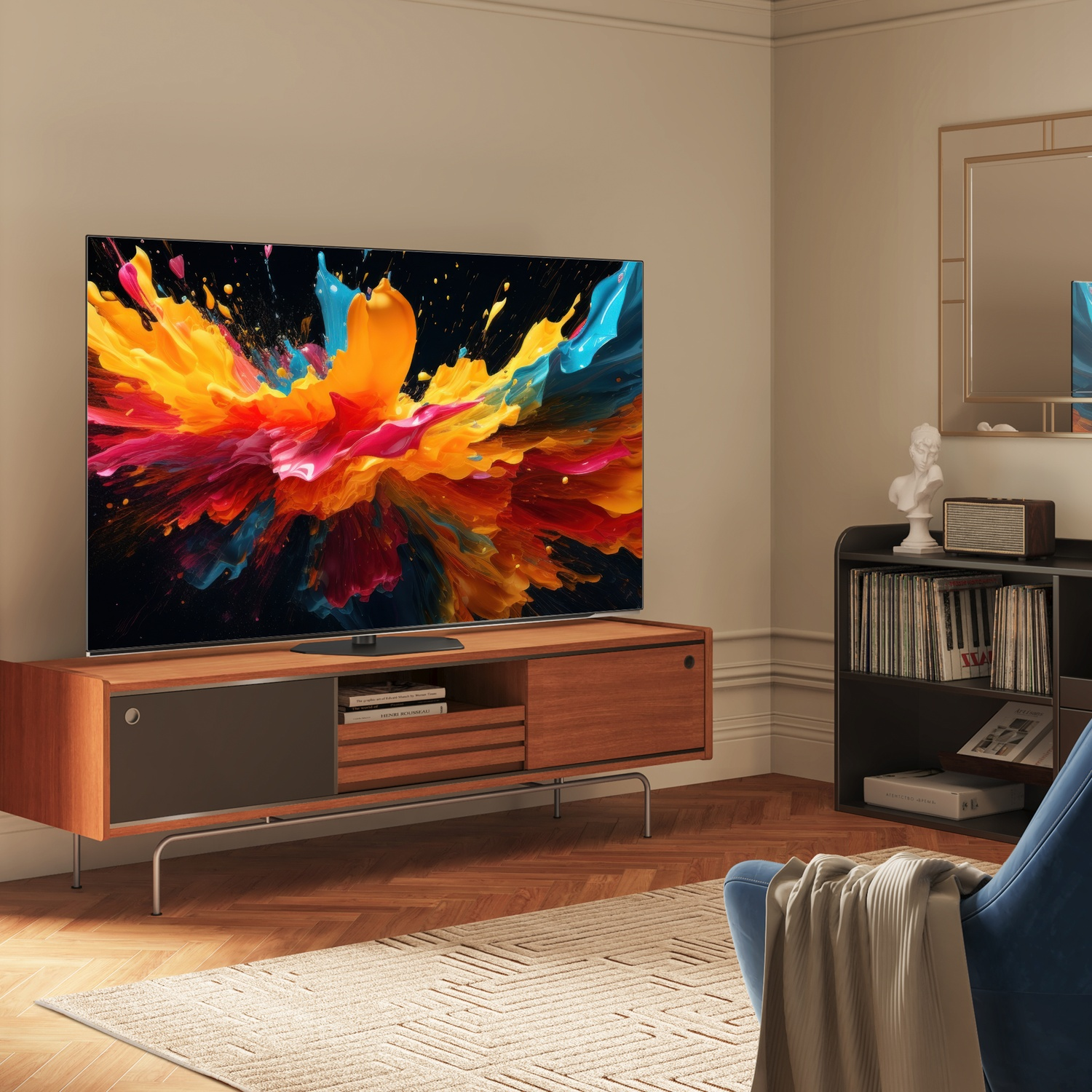 Soggiorno con TV che mostra arte astratta colorata. Mobile in legno, poltrona blu e specchio visibili.