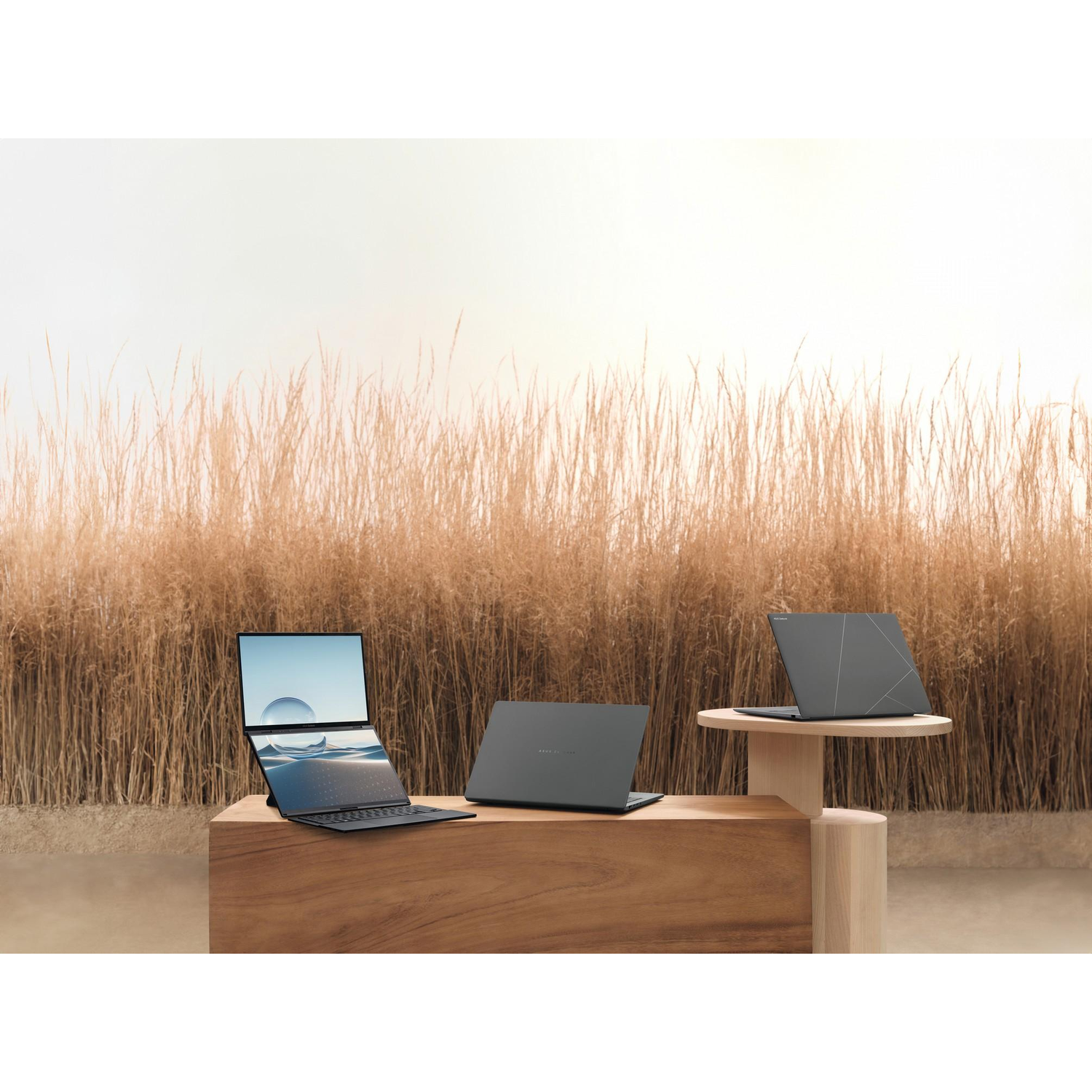 Laptops on display. Three laptops. One open, two closed. Brown table.