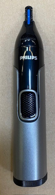 Trymer do nosa Philips na beżowej powierzchni. Czarne i szare urządzenie z niebieskimi akcentami. Widoczne logo 'PHILIPS'.