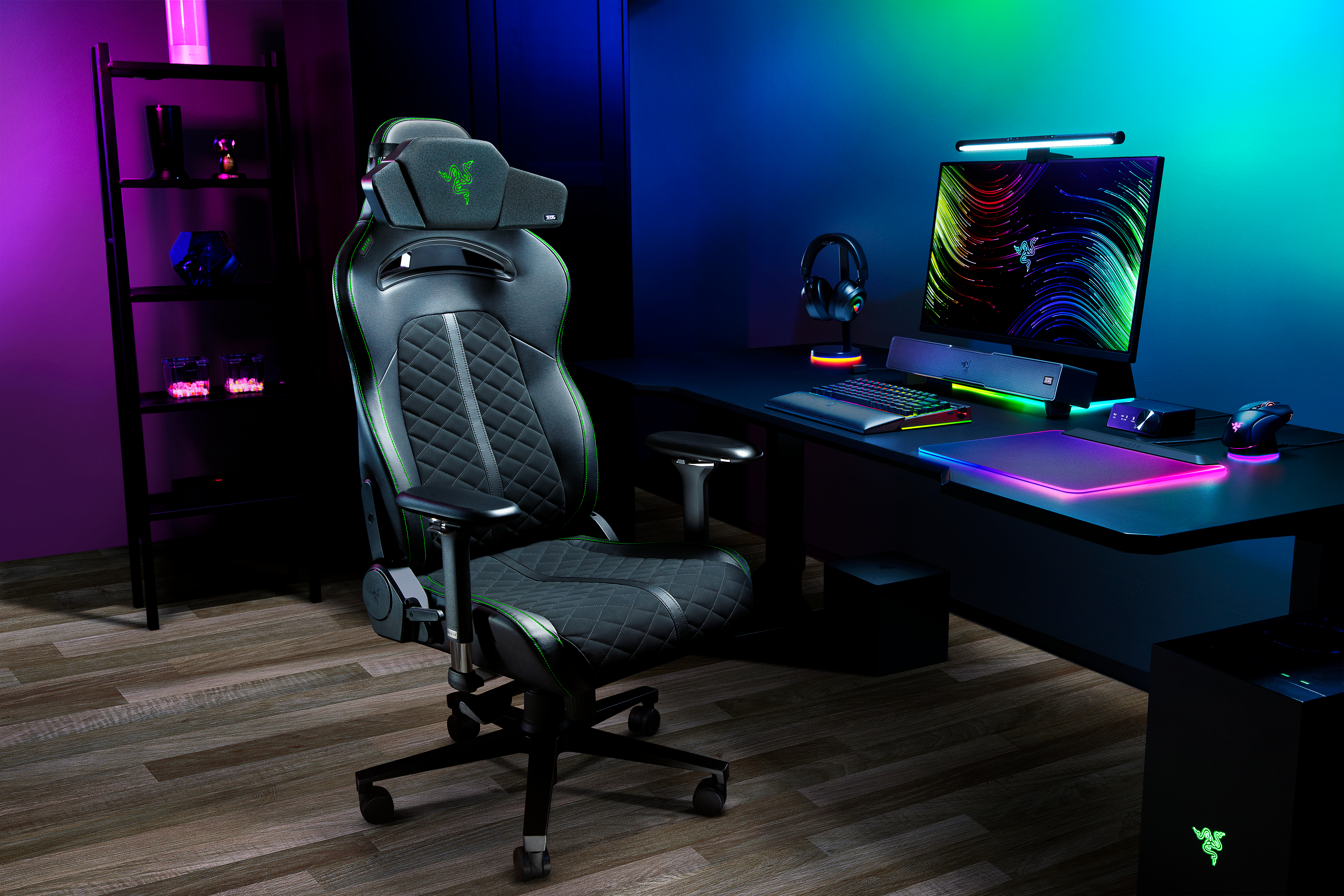 Gaming-Stuhl in einem Raum mit Computertisch, Monitor und Regalen. Der Raum hat Farbverläufe: lila, blau und grün.