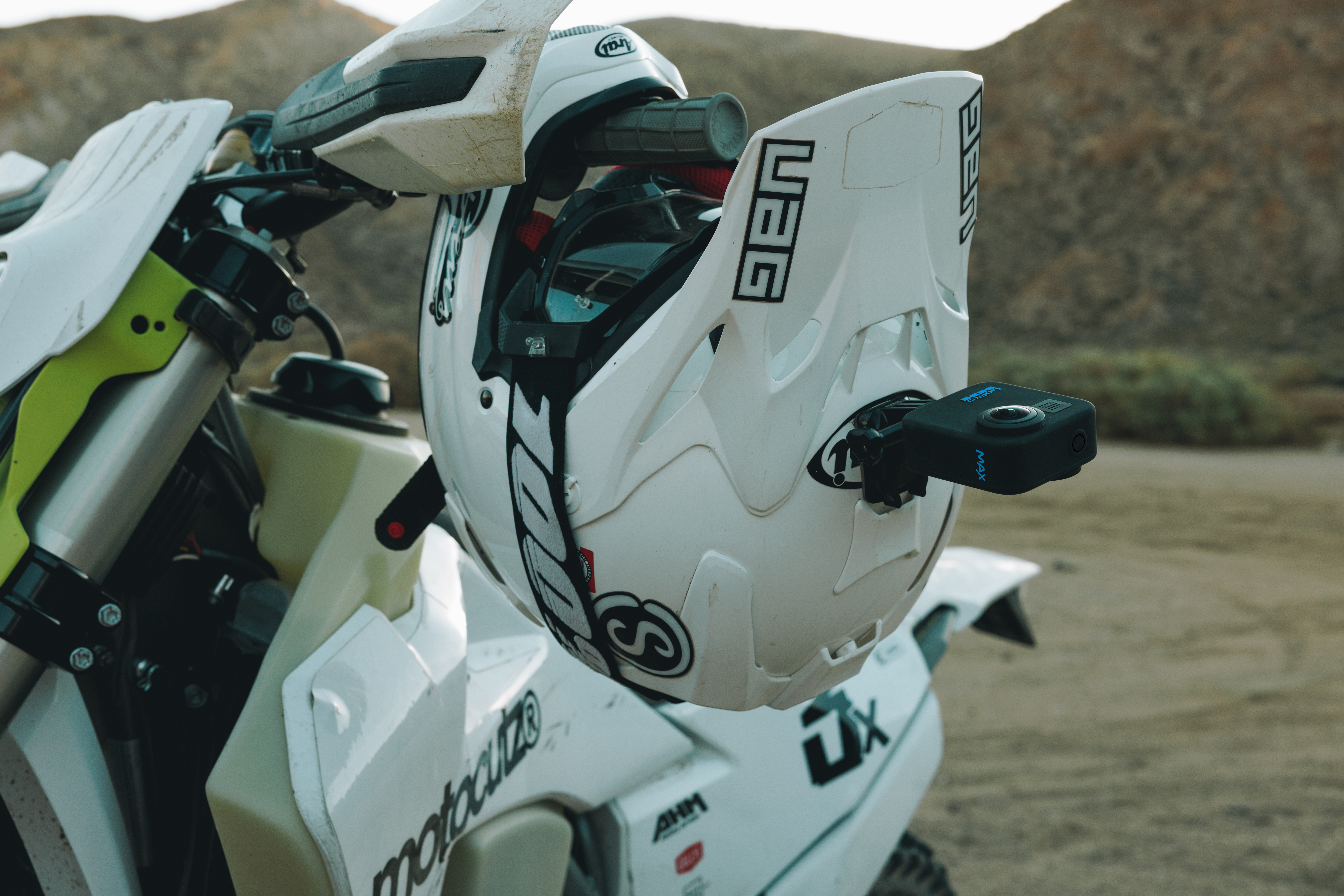 Weißer Helm auf einem Motorrad mit einer GoPro-Kamera. Wüstenhintergrund mit Bergen.