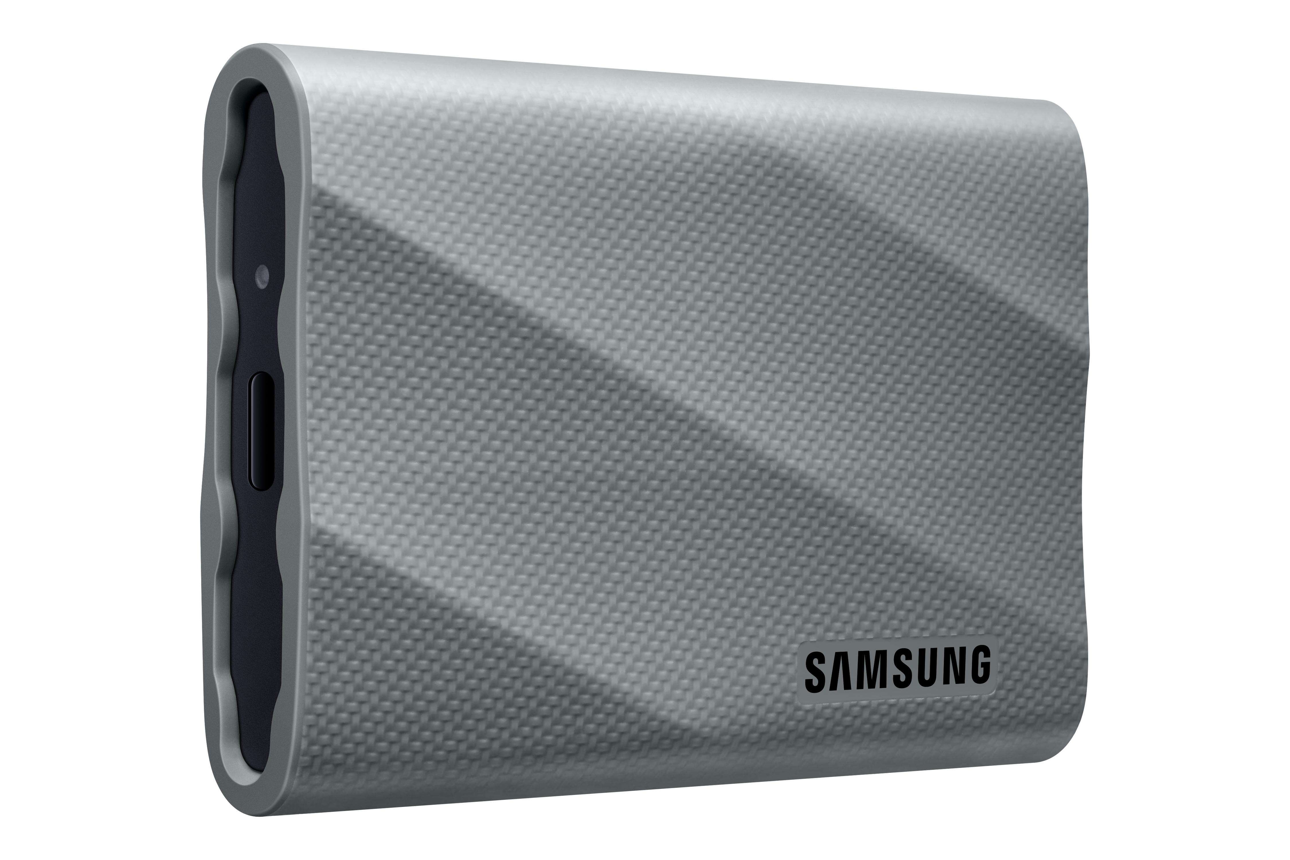Graue Samsung externe Festplatte, strukturierte Oberfläche, schwarze Seite mit Knopf und Logo auf weißem Hintergrund.