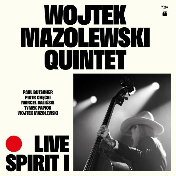 Albumcover mit Wojtek Mazolewski Quintet, einem Bassisten und einer Live-Performance-Umgebung.