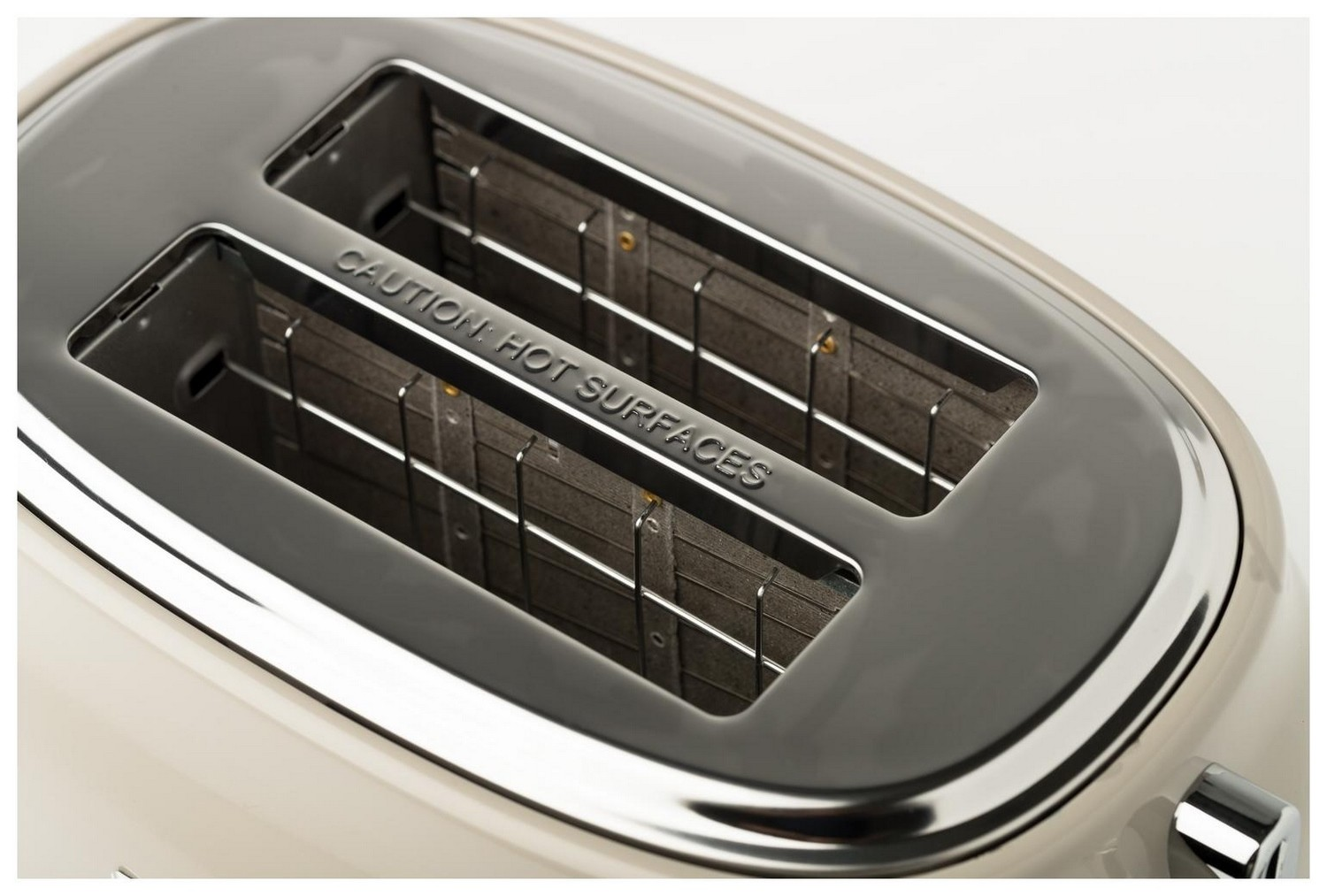 Wnętrze szarego tostera. Ostrzeżenia o gorącej powierzchni są widoczne. To Haden.