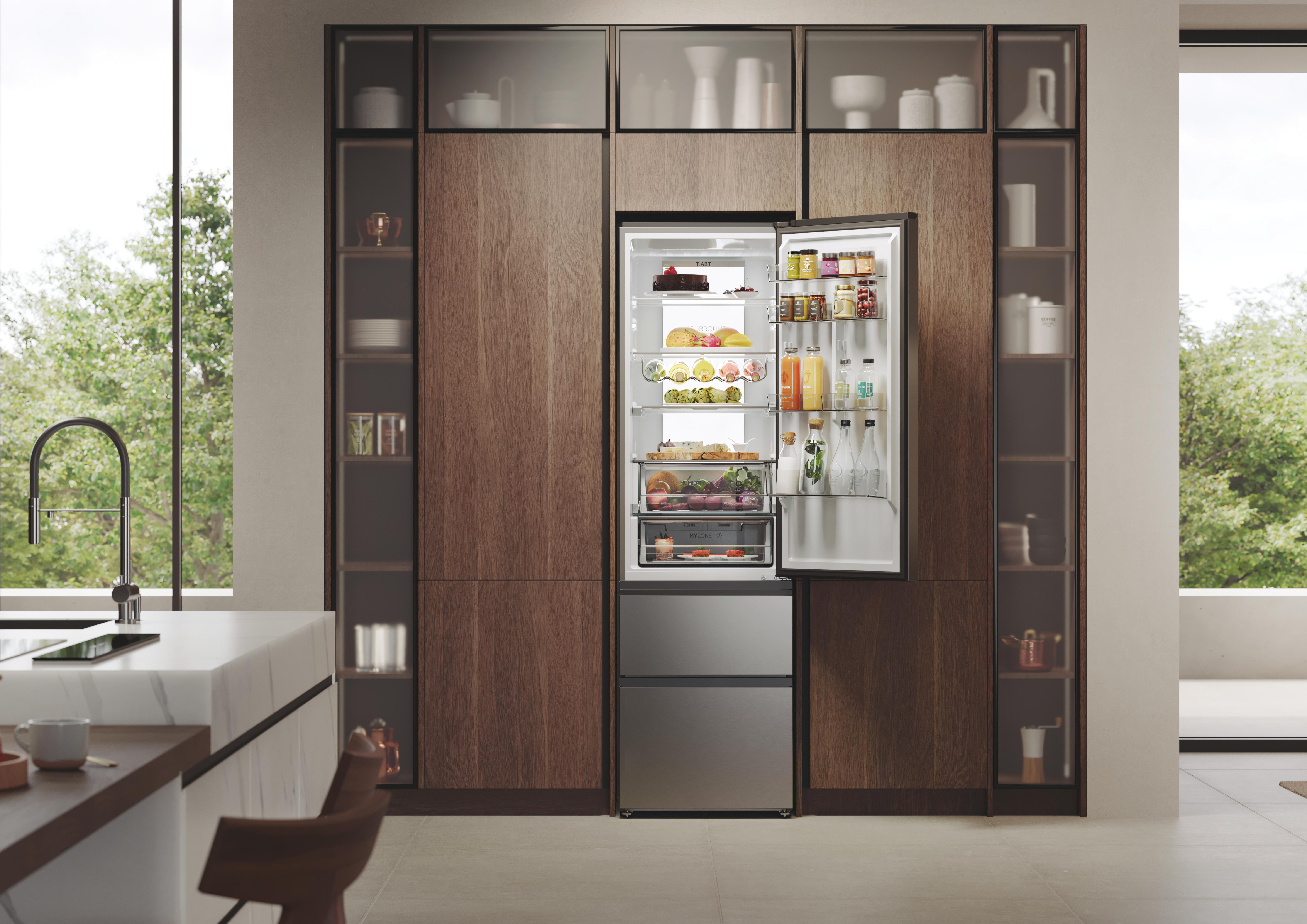 Ein moderner Kühlschrank mit offener Tür, der frische Lebensmittel und Getränke zeigt. In einer Holzküche.