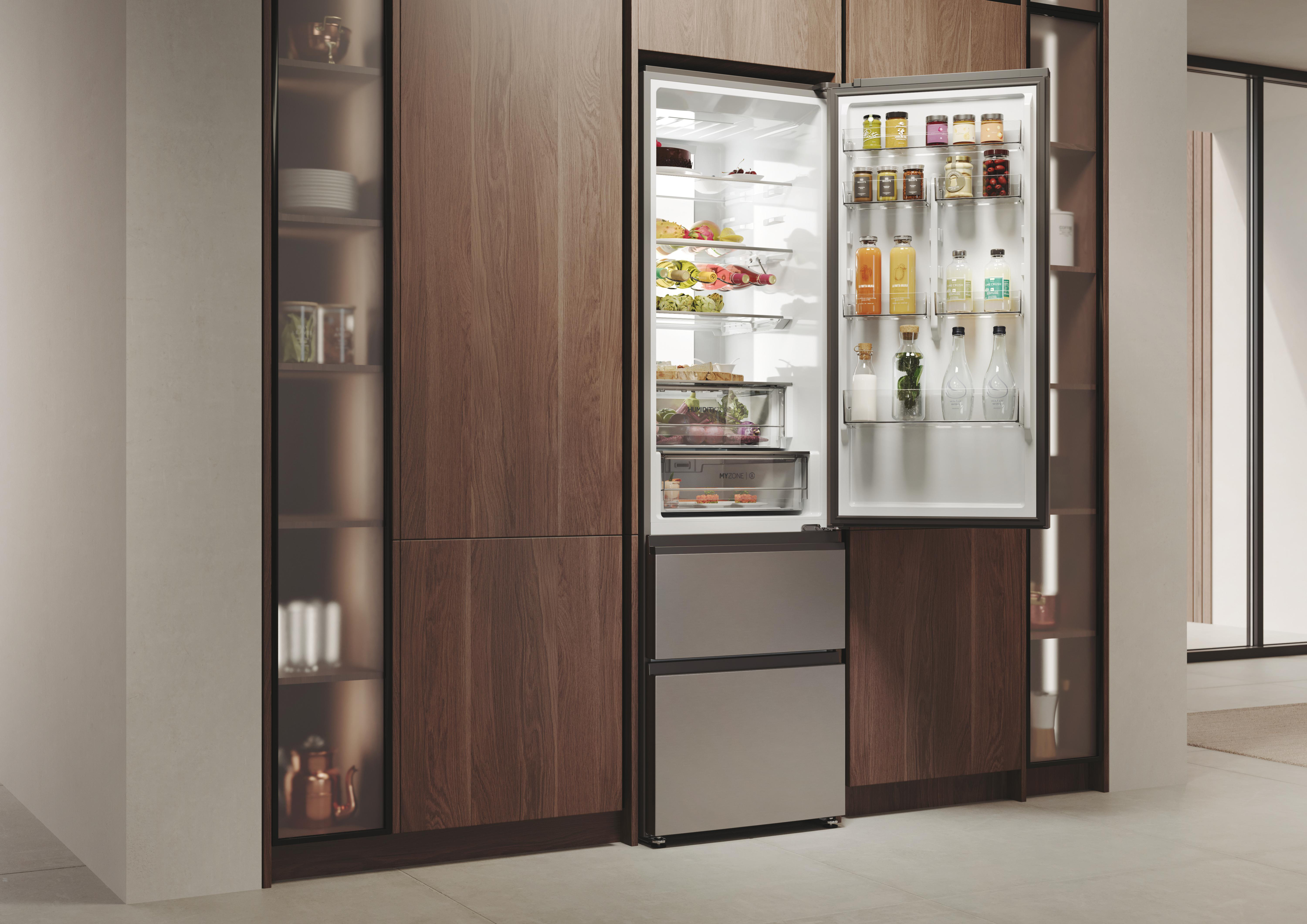 Ein Kühlschrank mit offener Tür, der Lebensmittel und Getränke zeigt. In einer Holzküche.