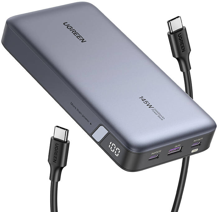 Szürke power bank 100-zal a kijelzőn, USB-C portokkal és fekete UGREEN kábelekkel.