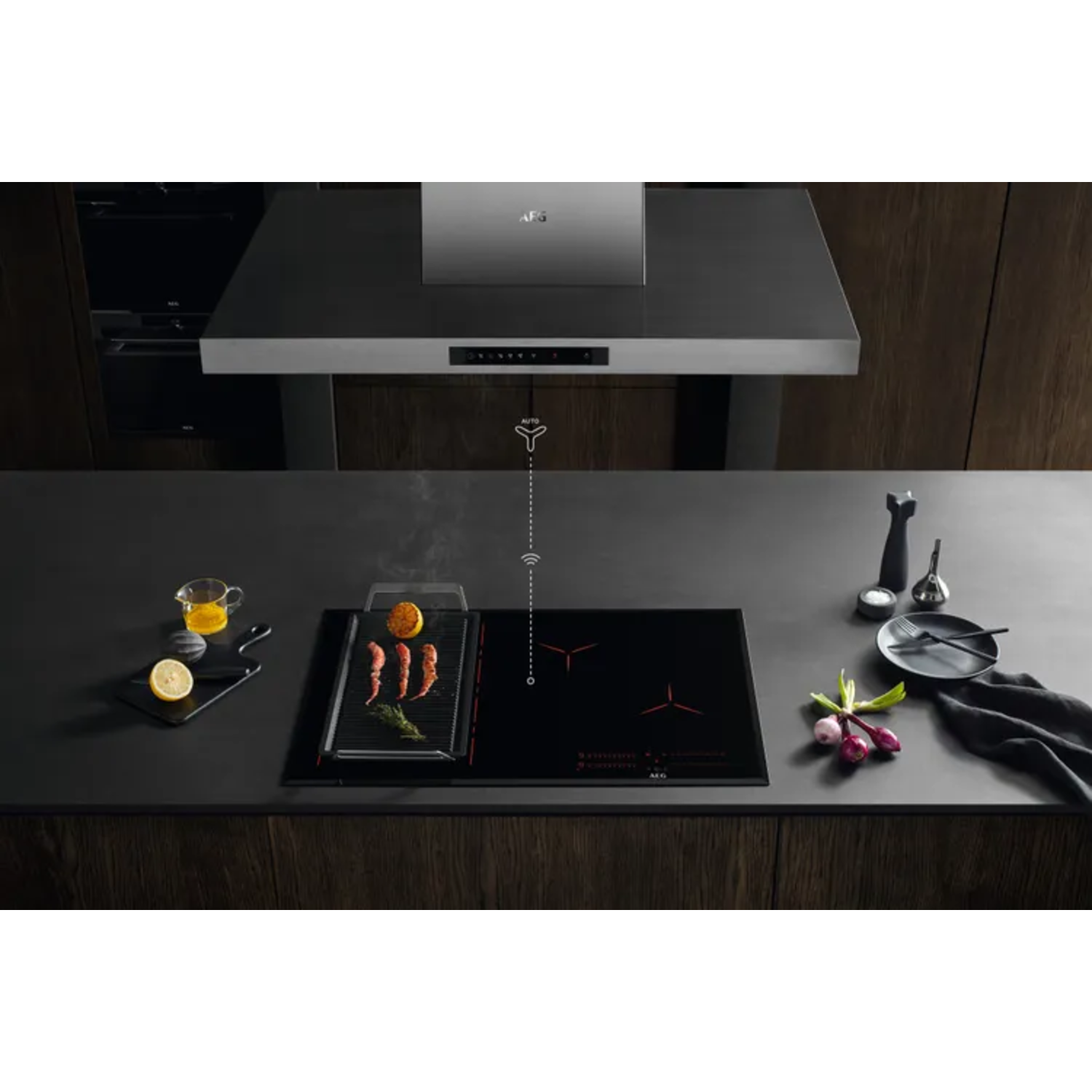 Kitchen scene with a cooktop and a hood. A grill is on the cooktop and a lemon.