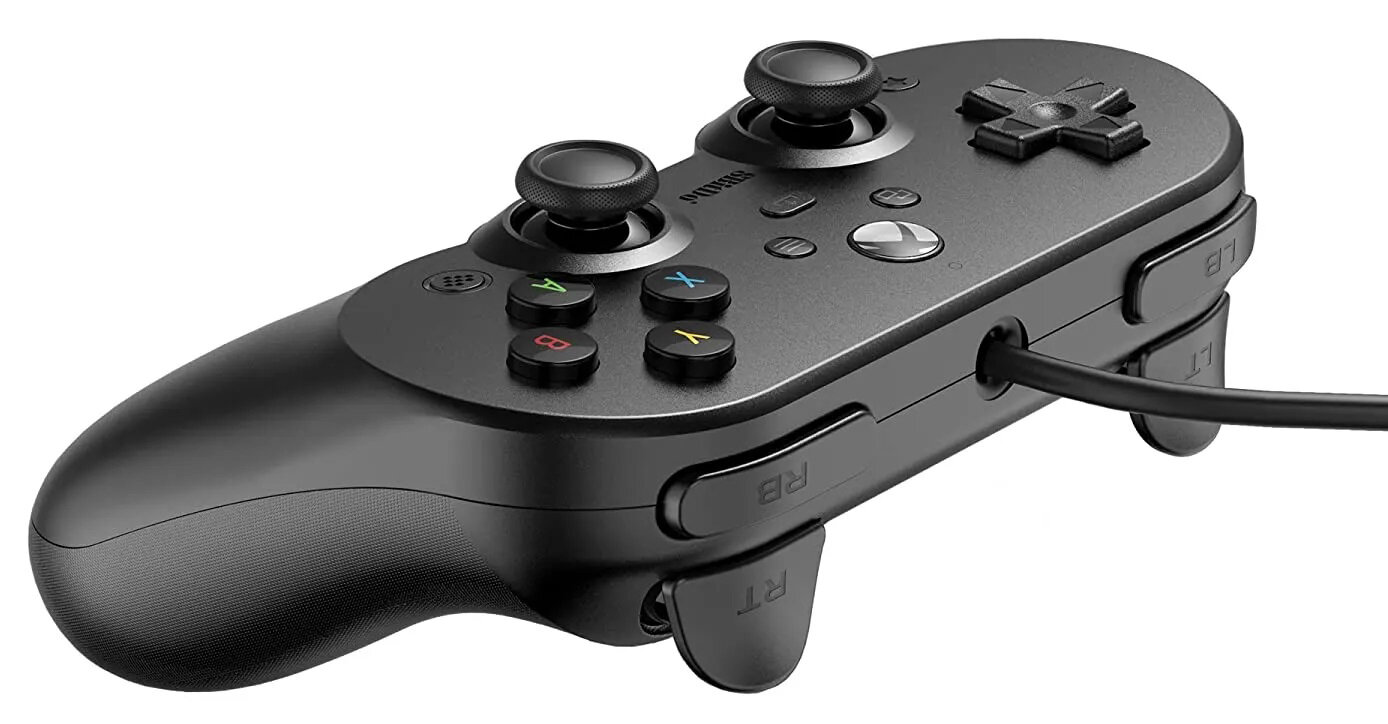 Czarny kontroler 8BitDo. Widok pod kątem, pokazujący przyciski, D-pad, joysticki i kabel.