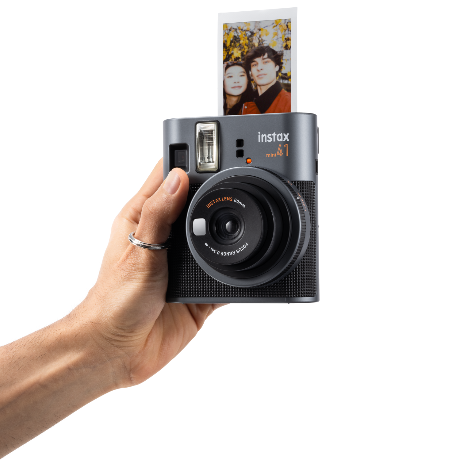 Hand holding Instax mini 41 camera and a photo.