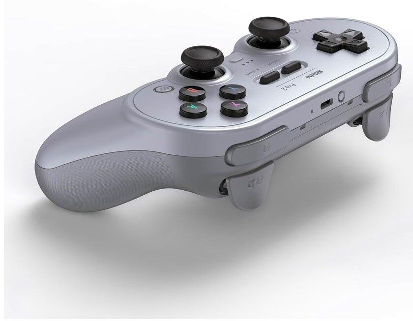 Widok pod kątem jasnoszarego gamepada 8BitDo Pro 2. Ukazuje gamepad i przyciski z pochylonej perspektywy.