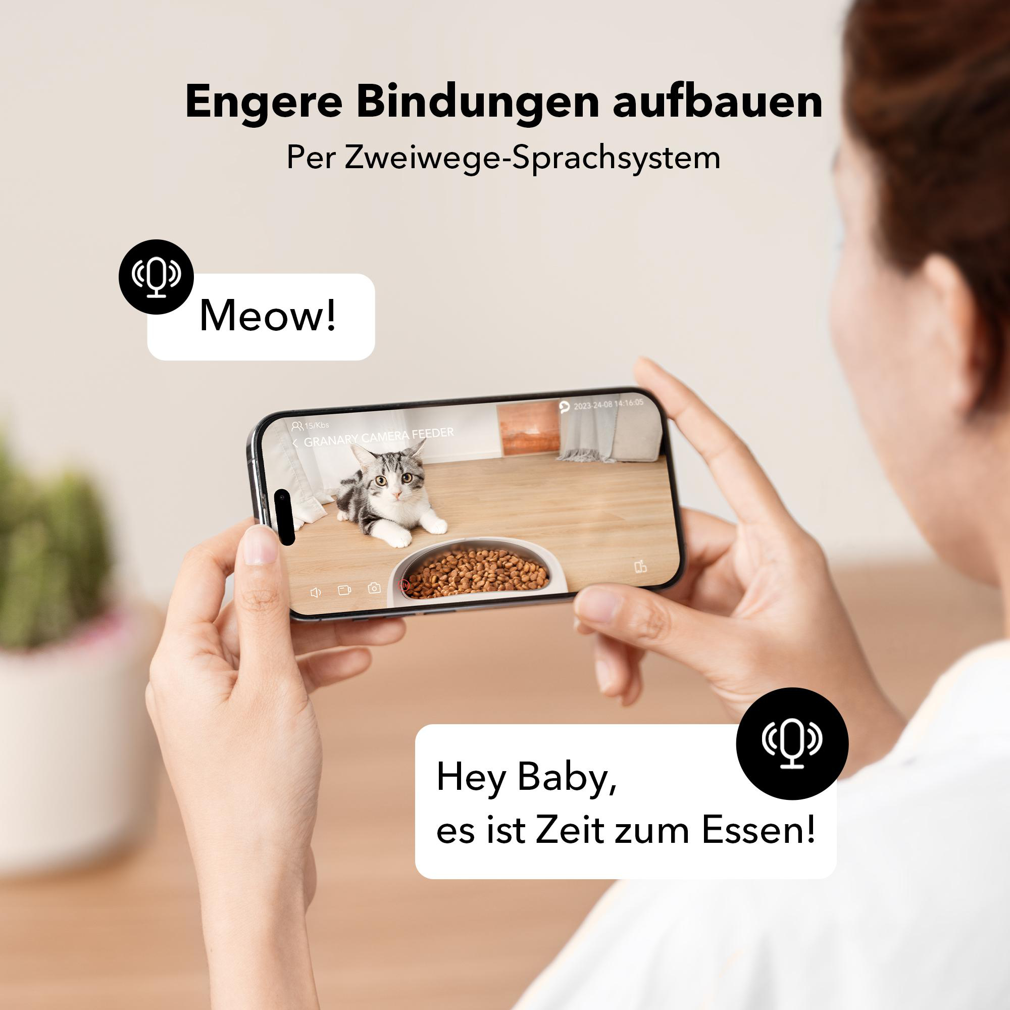 Eine Frau, die ein Telefon mit einer Katze in einer Schüssel auf dem Bildschirm hält, mit einer Textblase mit „Hey Baby, es ist Zeit zu essen!“