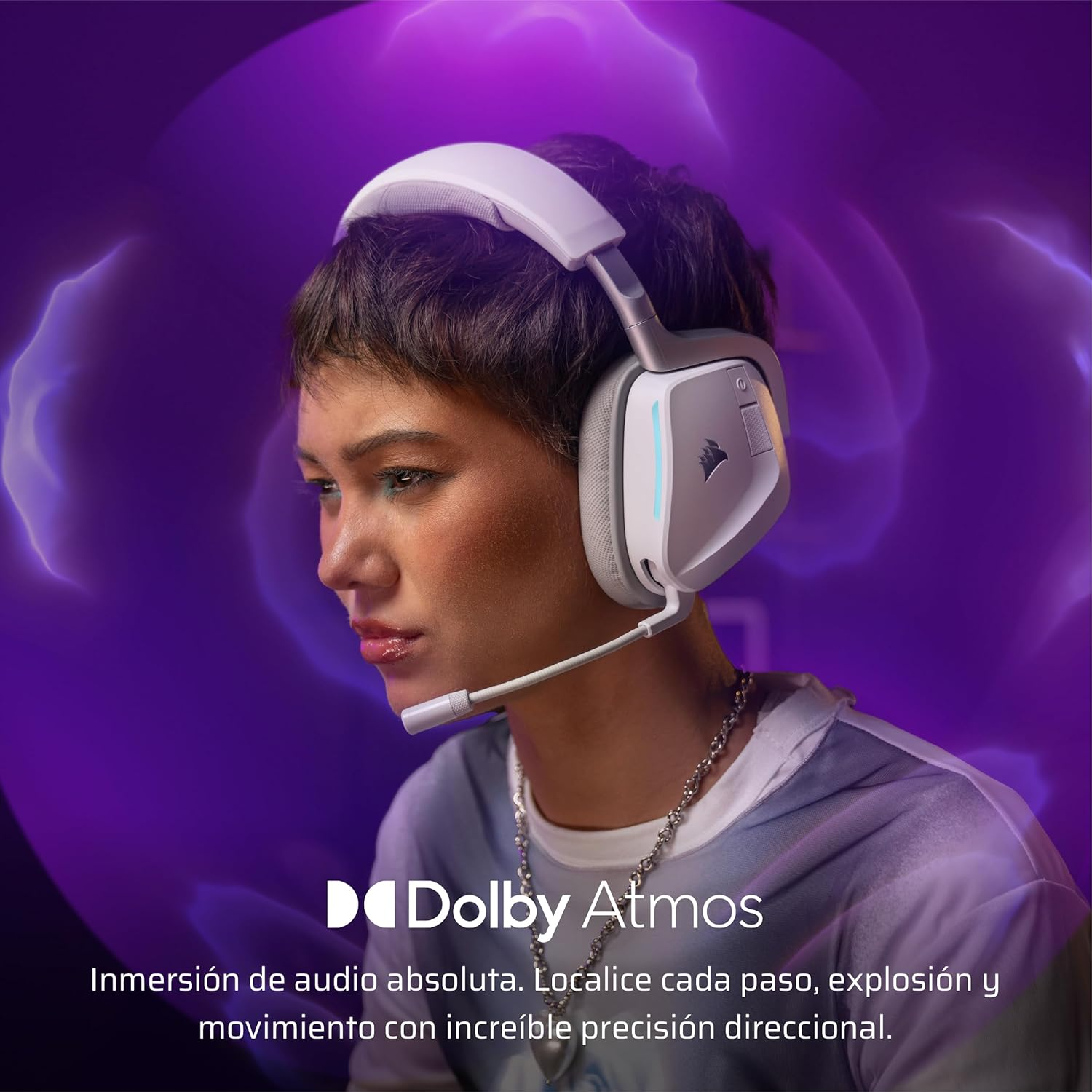 Una persona con unos auriculares blancos con micrófono. La imagen tiene un fondo morado y el texto dice Dolby Atmos.