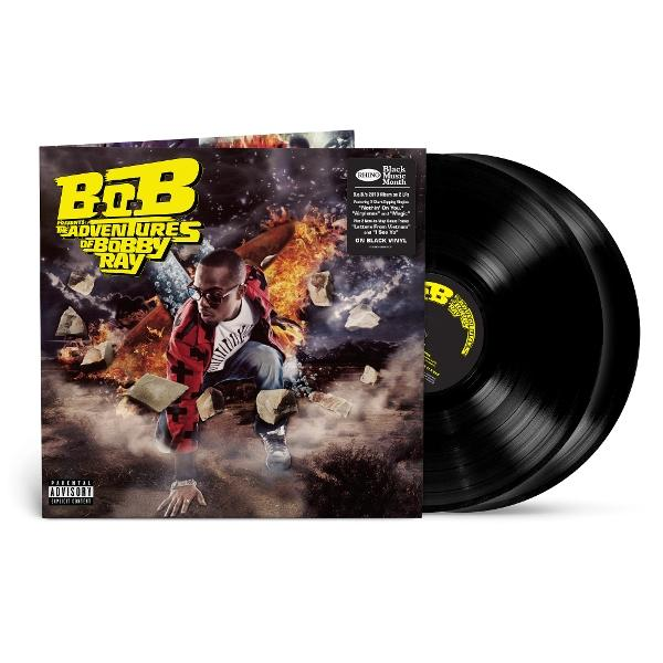 Album borító: B.o.B, művész, térdelve tűzzel és törmelékkel körülvéve, két fekete bakelit lemez.
