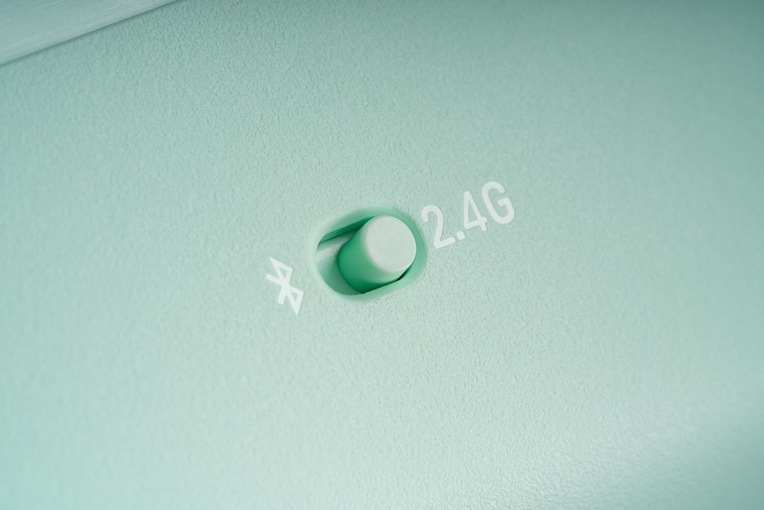 Zbliżenie przełącznika kontrolera z tekstem '2.4G' i symbolem Bluetooth.