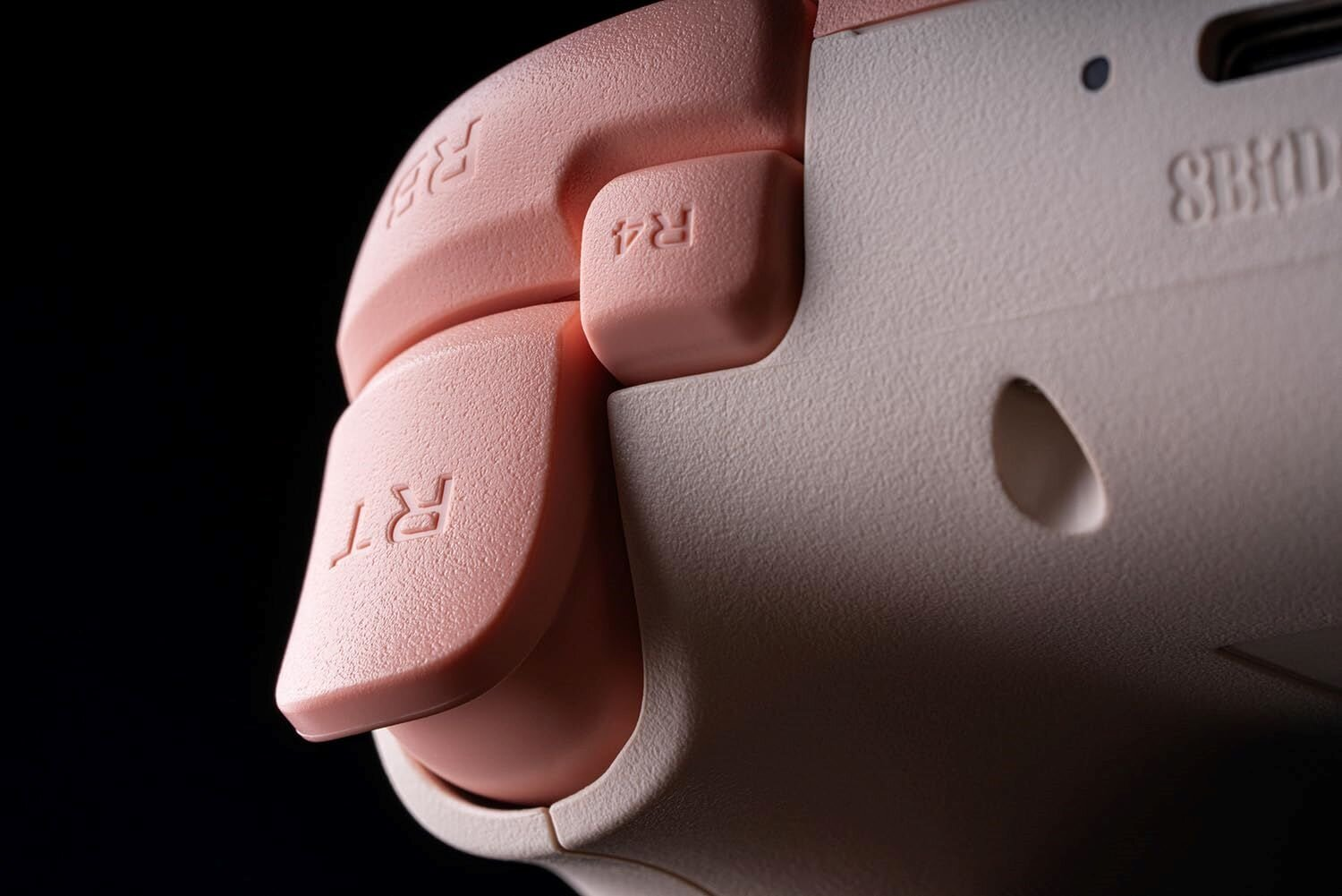 Zbliżenie przycisków na różowo-białym kontrolerze. RT, R4 są widoczne po prawej stronie.