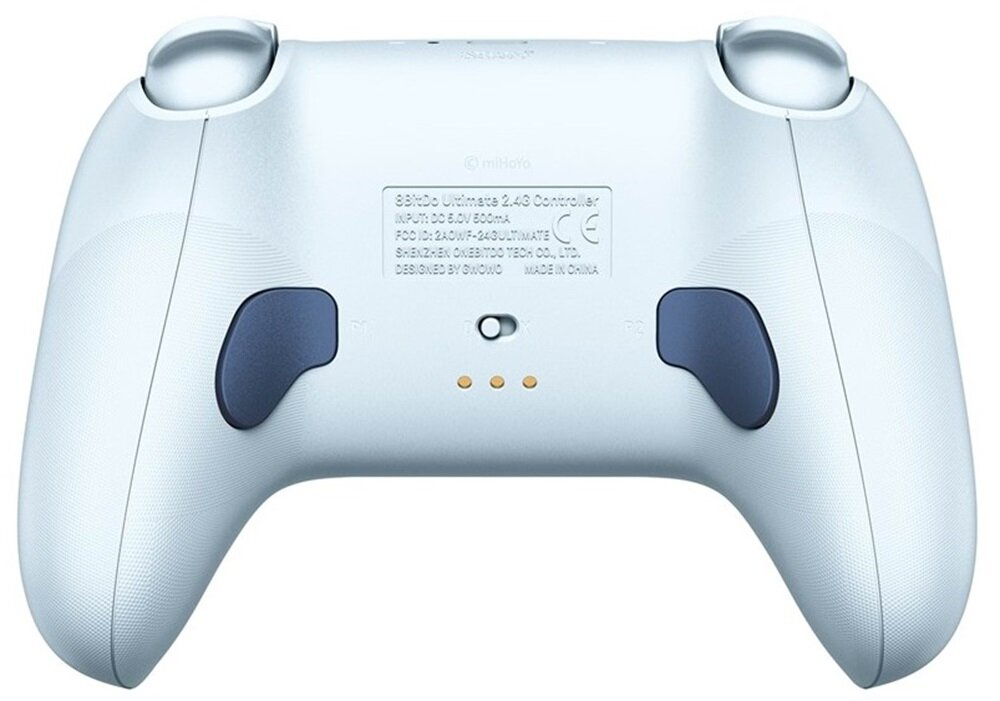 Widok z tyłu białego kontrolera z przyciskami. Pokazuje informacje o modelu i punkt ładowania. Ciemnoszare przyciski.