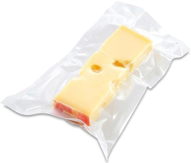 Blok żółtego sera w zgrzewanej próżniowo, przezroczystej plastikowej torbie. Ser ma dziury.