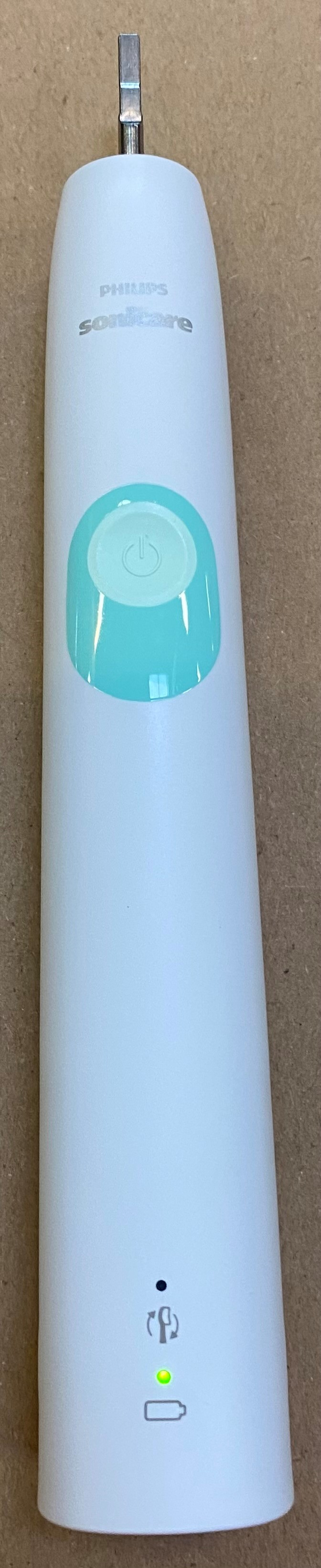 Biała szczoteczka do zębów Philips Sonicare, z przyciskiem zasilania i zielonym światłem, na białym tle.