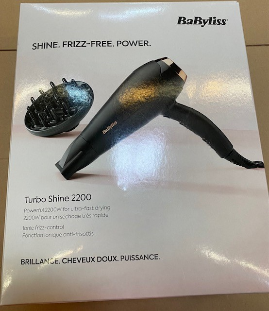 Pudełko czarnej suszarki do włosów i okrągłego mocowania. Marka to Babyliss.