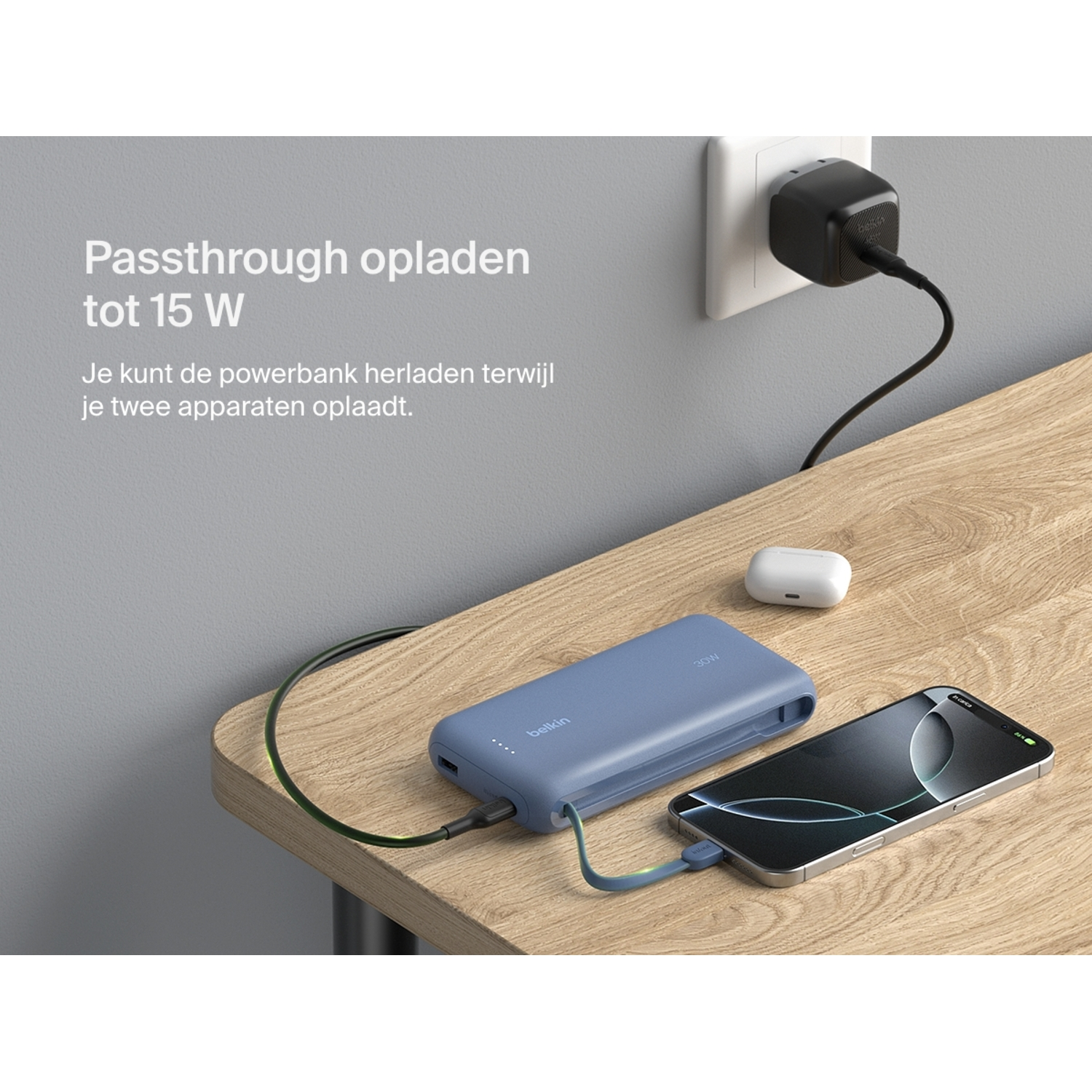 Belkin power bank plugged into wall and phone, with earbuds nearby on wooden table.