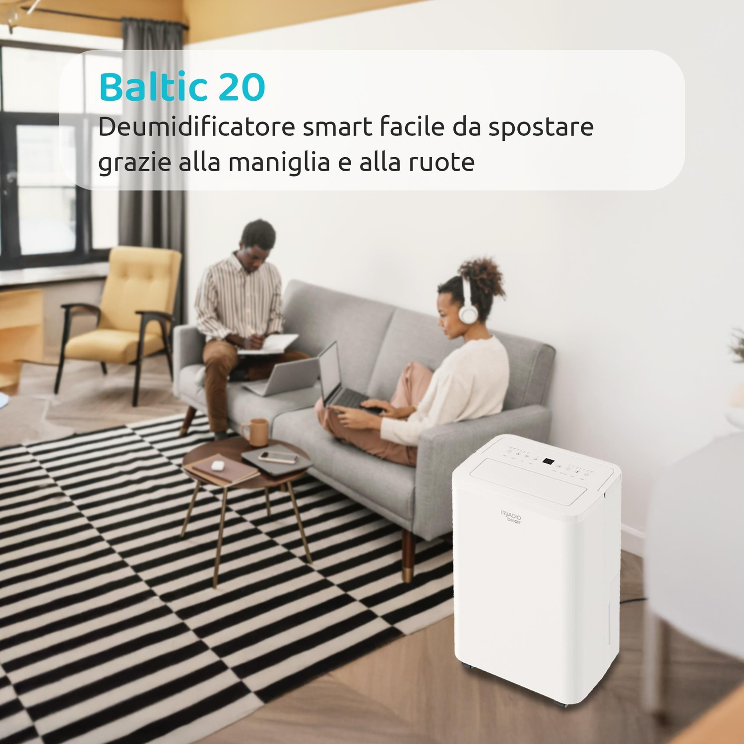 Due persone su un divano, un deumidificatore bianco sul pavimento. Tappeto bianco e nero.